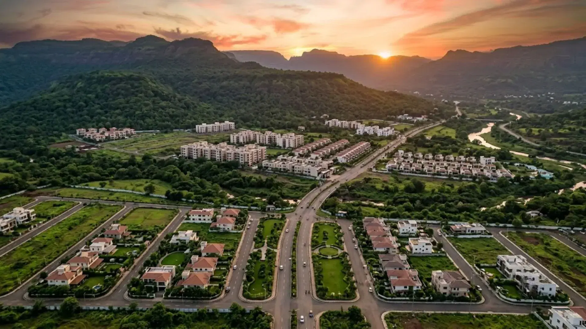 Aerial view of residential development in Neral surrounded by the Matheran hills at sunset